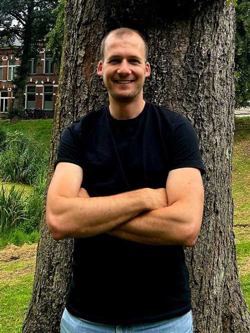 a man standing next to a tree